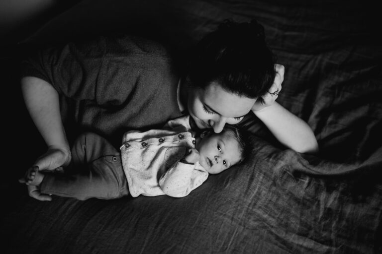 Pasgeboren baby fotoshoot op bed samen met mama zwart-wit